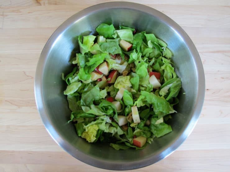 Fruit and lettuce tossed in a large bowl.