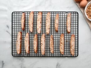 Horizontal overhead shot of a wire rack with baked mandel bread cooling on top.