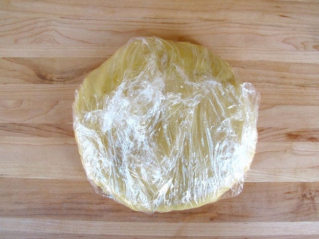 Dough disc wrapped in plastic to chill.