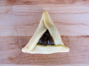 Pinch points of triangle so they remain shut while baking.