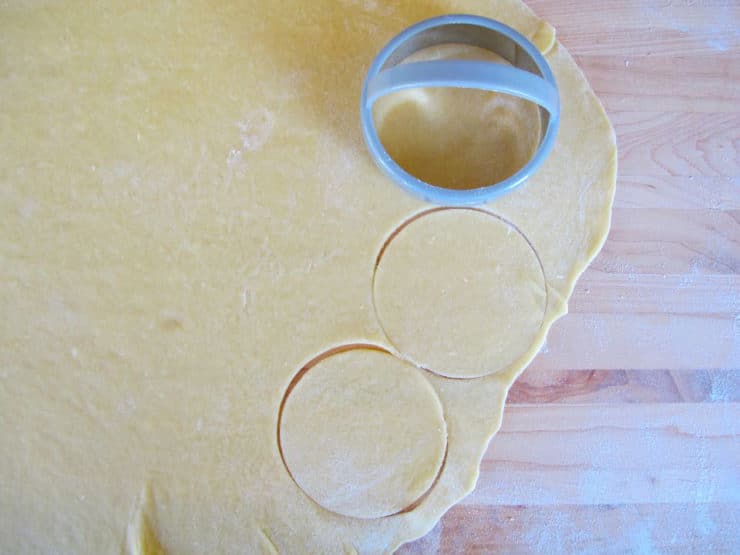 Using a biscuit cutter to cut circles of dough.