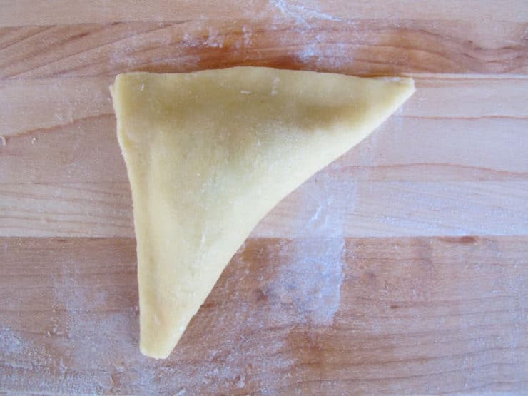 Square of dough folded into a triangle.