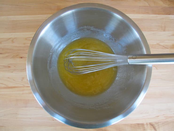 Eggs and oil whisked in a bowl.