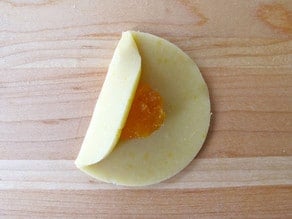 One side of dough circle folded over filling.