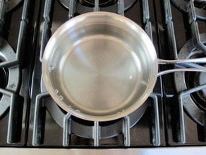 Saucepan with lightly simmering water on stovetop.
