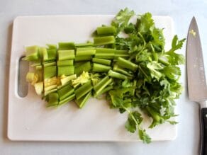Fresh celery chopped on a cutting board with knife