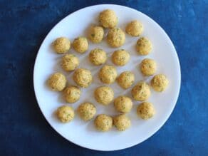 A plate of uncooked, rolled matzo balls, about 24 balls.