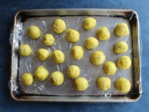 Matzo balls on a plastic wrap-lined baking tray, ready for freezing.
