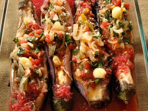 Turkish Imam Bayildi - Imam Fainted. Roasted eggplant stuffed with onions, garlic and peppers in sauce from Ilke of Ilke's Kitchen. Pareve, Vegan, Kosher for Passover.