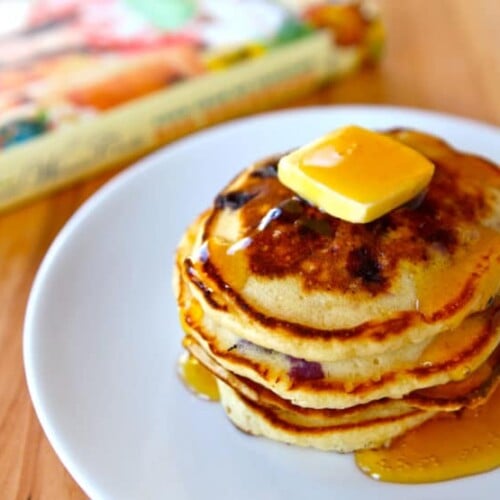 A stack of Lemon Blueberry Pancakes topped with butter and syrup