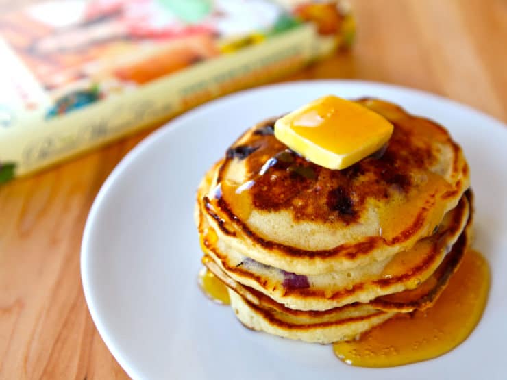 A stack of Lemon Blueberry Pancakes topped with butter and syrup