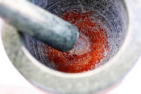 Grinding saffron with mortar and pestle.