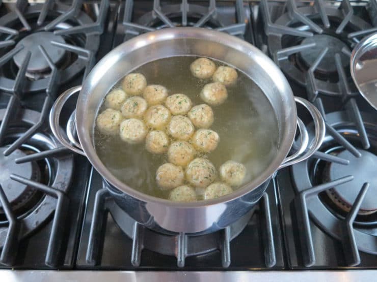 Matzo balls cooking in chicken stock.