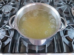 Stockpot of boiling chicken stock.