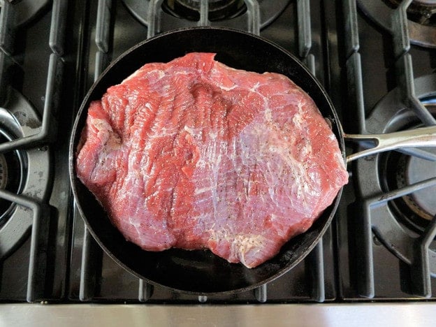 Searing brisket in a skillet.