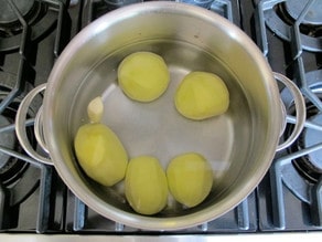Peeled potatoes in boiling water.