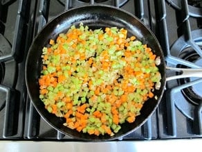 Diced carrots added to onions in skillet.