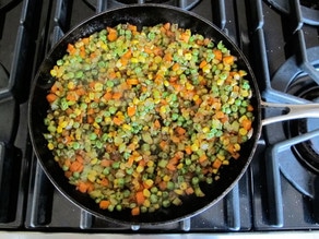 Diced carrots added to onions in skillet.