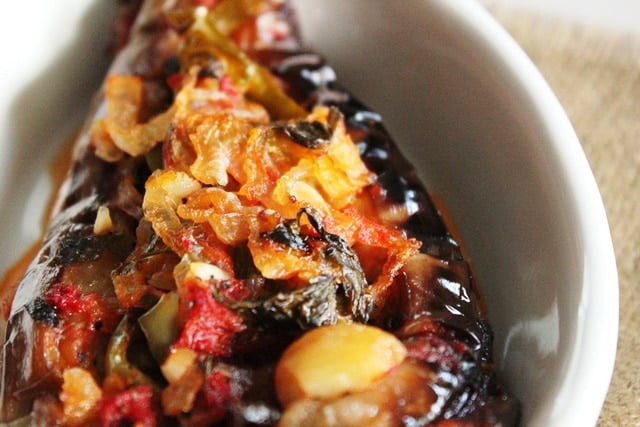 Turkish Imam Bayildi - Imam Fainted. Roasted eggplant stuffed with onions, garlic and peppers in sauce from Ilke of Ilke\'s Kitchen. Pareve, Vegan, Kosher for Passover.