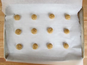 Biscuit dough on a lined baking sheet.