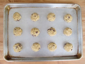 Cookie dough scooped onto a lined baking sheet.
