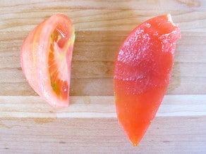 Pulp and seeds separated from skin of tomato quarter.