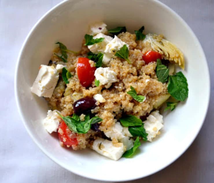 Greek Infused Quinoa Salad - A gluten free vegetarian salad with quinoa for protein, fresh oregano, olives, tomatoes, artichokes and lemon zest. Kosher for Passover, dairy.