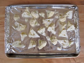 Cauliflower florets on a baking sheet.