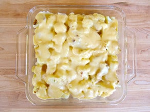 Cheese sauce poured over cauliflower florets.