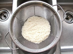 Rinsing rice in a strainer.