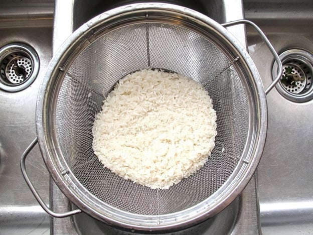 Rinsing rice in a strainer.