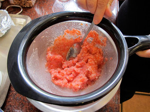 Straining liquid from blended tomatoes.