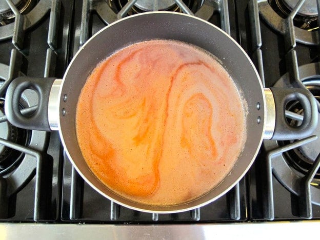 Tomato juice and water added to rice.