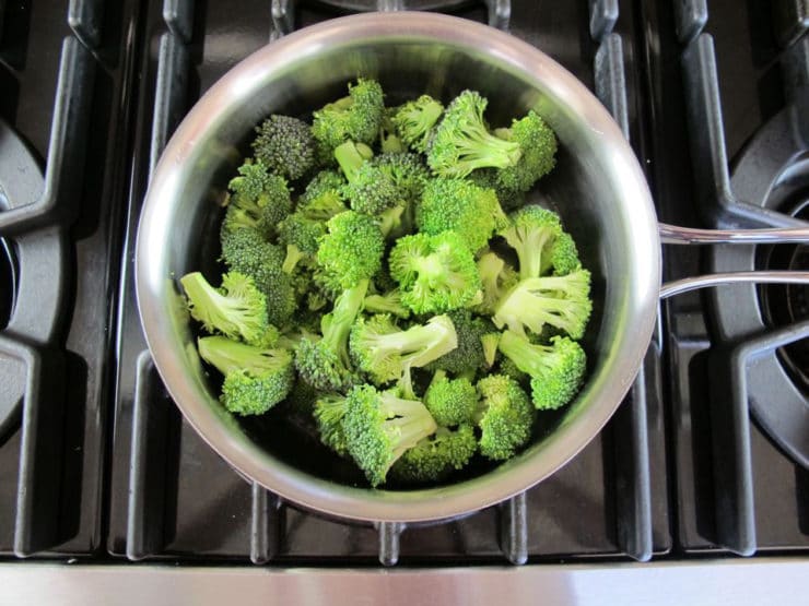 Broccoli florets in a saucepan.