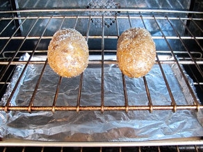 Potatoes on an oven rack to bake.