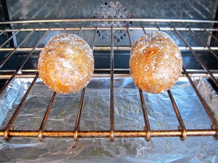 Potatoes on an oven rack to bake.
