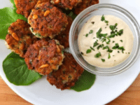A plate of Israeli-style fish cakes with a dip, showcasing golden brown crab cakes served with a flavorful sauce