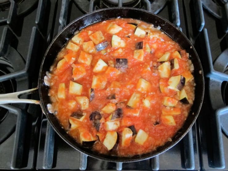 Eggplant and tomato added to skillet.