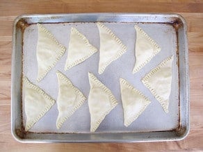 Bourekas on a parchment lined baking sheet.