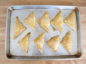 Baked Bourekas on a parchment lined baking sheet.