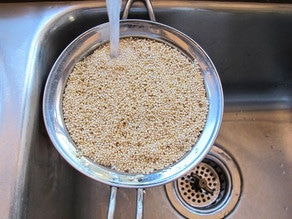 Rinsing quinoa in a strainer.