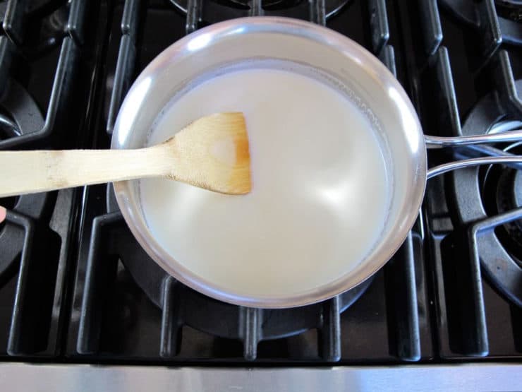 Slowly heating milk in a saucepan.