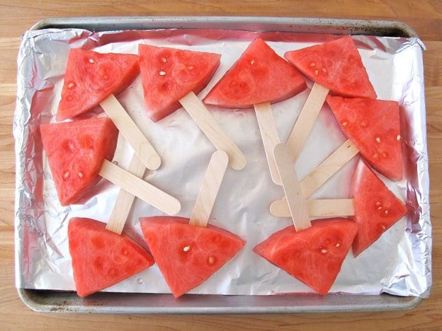 Watermelon pops on foil lined baking sheet.