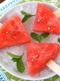 Watermelon Mojito Pops on a plate garnished with fresh mint leaves