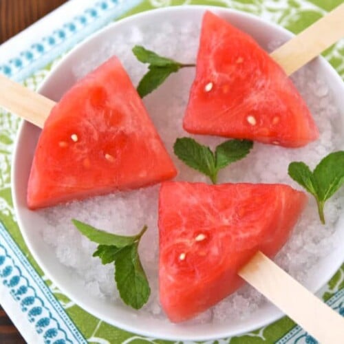 Watermelon Mojito Pops on a plate garnished with fresh mint leaves