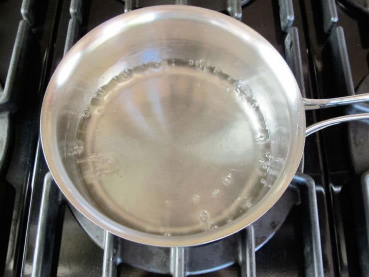 Heating simple syrup in a saucepan.