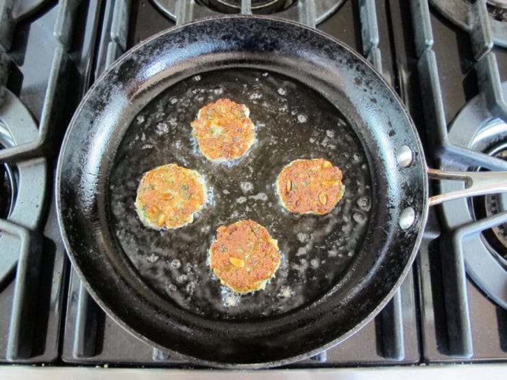 Frying fish cakes in a skillet.