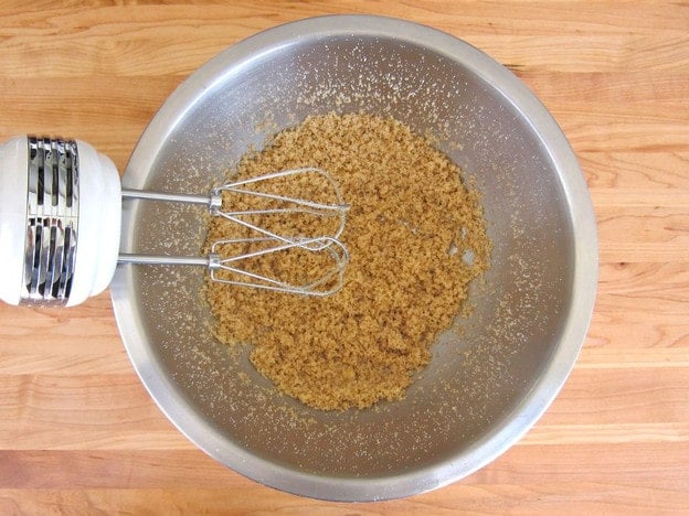Beating butter and sugar with a hand mixer.