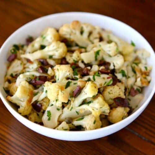 Slant image of Italian Roasted Cauliflower Salad serve on a white bowl.