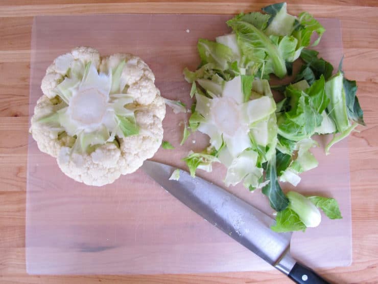 Cutting the stem off a head of cauliflower.